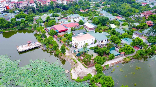  Cách mặt phố Đặng Thai Mai chưa đầy 100m, qua con đường bê tông đã được kiên cố hóa chạy cắt ngang hồ Đầm Trị, một loạt những căn biệt thự rộng hàng trăm mét vuông lần lượt hiện ra. 