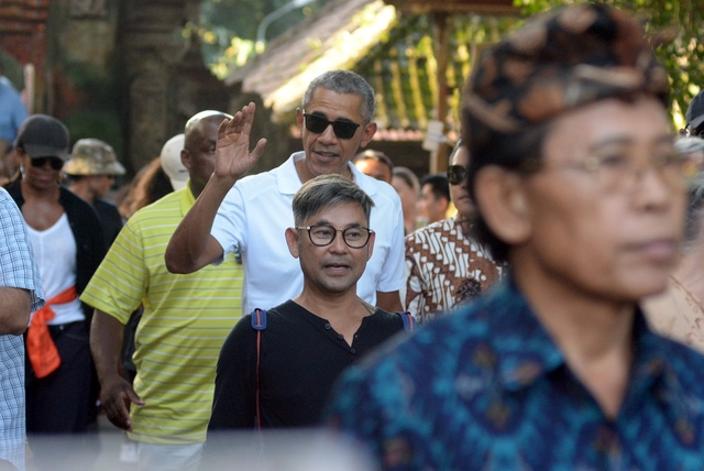 Cựu Tổng thống Obama từng dành 4 năm tuổi thơ tại Indonesia sau khi mẹ ông tái hôn với một người đàn ông Indonesia, do vậy chuyến đi lần này của ông Obama được xem như một chuyến “hành hương” về quê hương cũ. Trong ảnh: Ông Obama mỉm cười với những người dân Indonesia đang đứng chờ ông tại khu vực đền Tirta Empul (Ảnh: Reuters)