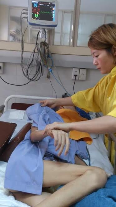  Chị Huệ bên cạnh cậu con trai tội nghiệp. Ảnh: V.Sĩ 