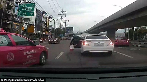 Bé gái đột ngột ngã lăn từ trên ô tô đang chuyển bánh xuống đường phố đông đúc - Ảnh 2.