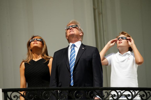  Ông Trump sau đó đã đeo kính bảo vệ để xem nhật thực (Ảnh: Reuters) 