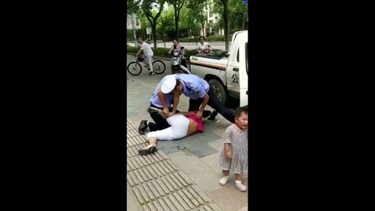 Trung Quốc: Cảnh sát quật ngã người phụ nữ đang đang bế trẻ - Ảnh 5.