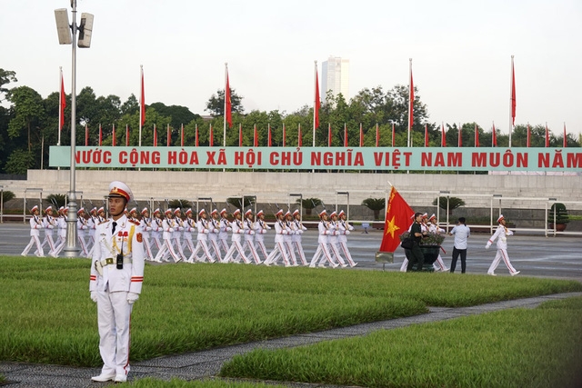  Đúng 6 giờ, lễ chào cờ bắt đầu, các chiến sỹ đội nghi lễ của Đoàn 275 thuộc Bộ Tư lệnh bảo vệ lăng Chủ tịch Hồ Chí Minh tiến ra quảng trường Ba Đình trong âm hưởng bài hát Tiến bước dưới Quân kỳ. 
