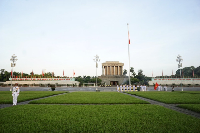  Nhạc Quốc ca vang lên, mọi hoạt động trên quảng trường tạm dừng, người dân hướng về cột cờ phía trước lăng Chủ tịch Hồ Chí Minh. 