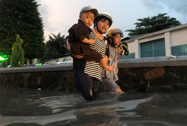 Người dân vô cùng vất vả bì bõm lội qua khu vực ngập nước.