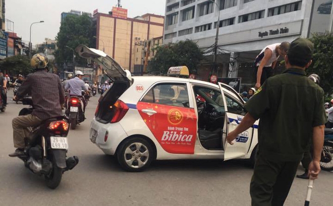 Bị nhắc nhở đi vào đường cấm, tài xế taxi trèo lên nóc xe ăn vạ