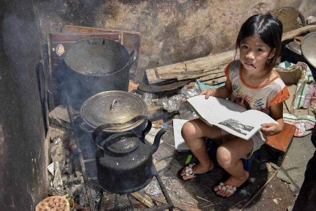  Công việc ngoài đồng cả ngày, nên bé Sáng đảm đang thay việc mẹ chăm sóc và nấu cơm nước cho các em ở nhà. Hình ảnh này được ghi lại khi chúng tôi bất ngờ tìm đến, bé Sáng đang tranh thủ ngồi học khi nấu cơm để sáng mai đi học vì tối nhà ăn cơm muộn lại đông người không có chỗ học bài. 