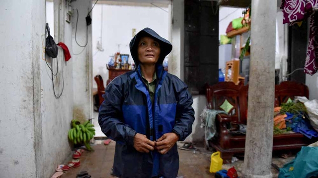  Do trời mưa to, bà Hải chạy vội từ ngoài đồng về qua nhà vì lo cho các con vụng dại. Về một lát chị lại vội mặc áo mưa ra đồng để tiếp tục bắt ốc, tôm bán lấy tiền trang trải cuộc sống, lấy tiền mua sách vở cho 6 đứa con vào năm học mới. 