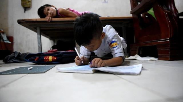  Bé Út đang tranh thủ làm bài tập về nhà khi các anh chị đã đi chơi bên nhà hàng xóm. ”Nếu anh chị ở nhà, nhà không còn chỗ nào để học. Em đợi mọi người đi làm đi chơi hết em mới làm bài tập. Phải tranh thủ không mai lên lớp cô giáo phạt”, bé Út nói. 