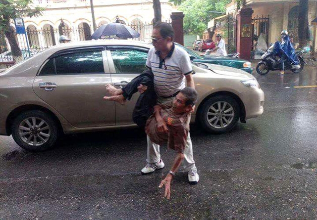  Hình ảnh tài xế ô tô bế ông cụ vào lề đường kiếm tra rồi cho đi bệnh viện. Ảnh: (Bạn đọc cung cấp) 