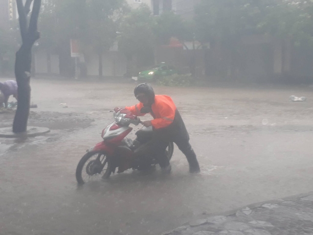  Người dân di chuyển khó khăn trong mưa bão... 