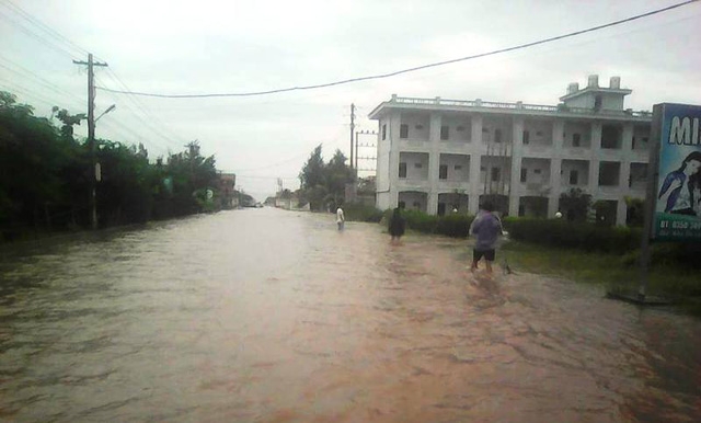  Nước biển dâng cao gây ngập lụt khiến người dân đi lại vô cùng khó khăn (ảnh: Phùng Thành) 