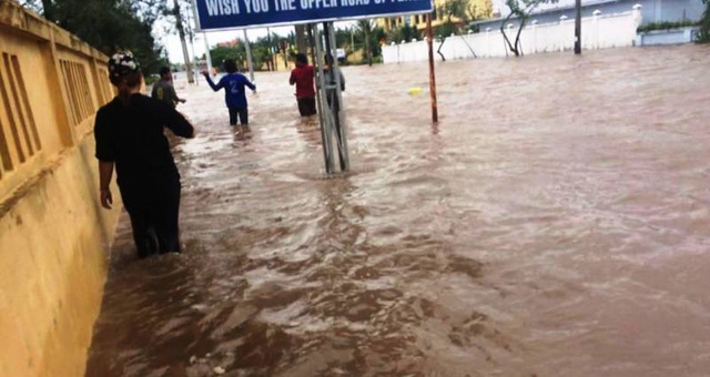 Người dân bì bõm lội nước trên các tuyến đường bị ngập (ảnh: Phạm Tùng)