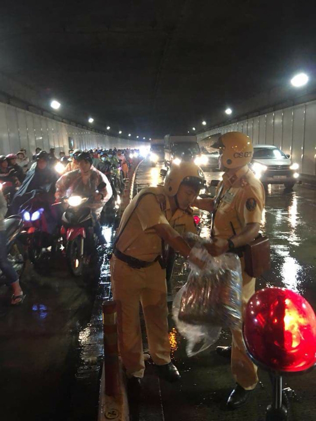 Trời bất ngờ đổ mưa giữa đêm Trung thu, 2 CSGT phát áo mưa miễn phí cho người dân trong hầm Thủ Thiêm - Ảnh 3.