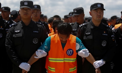 Cảnh sát Trung Quốc áp giải một nghi phạm lên máy bay ở sân bay Phnom Penh, Campuchia, ngày 12/10. Ảnh: Reuters.