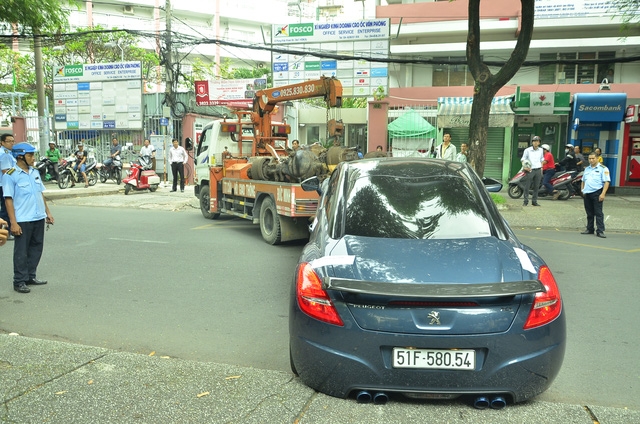 Một chiếc ô tô đậu trên vỉa hè bị tổ liên ngành cẩu đi