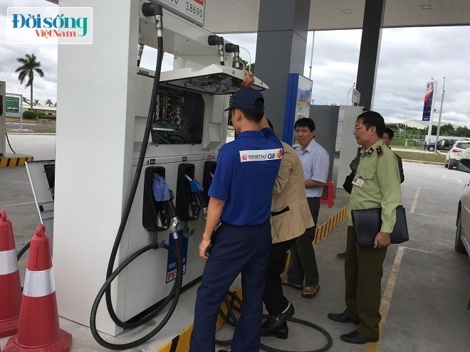 Cán bộ thị trường đang đi dán tem mác đạt chuẩn tại cây xăng chuẩn Nhật