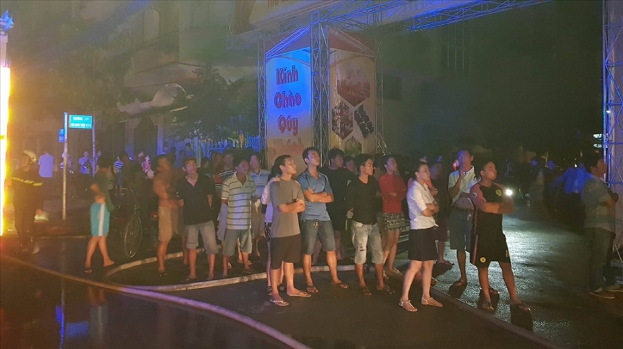 Hàng chục khách hát tháo chạy ra ngoài đang theo dõi lực lượng chữa cháy đưa các nạn nhân bị kẹt ra khỏi tòa nhà. Ảnh: Trường Sơn