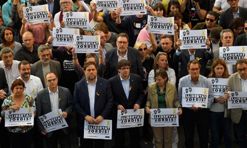 Ông Carles Puigdemont cùng các quan chức của vùng Catalonia và người dân biểu tình ở Barcelonia ngày 21/10 đòi Madrid phóng thích hai quan chức của vùng đang bị bắt giữ vì cáo buộc xúi giục nổi loạn. Ảnh: AFP.