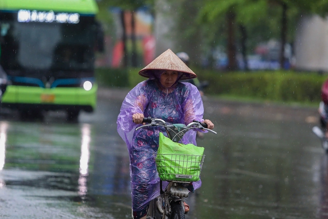 Trên đường Nguyễn Trãi, vẫn có một số phương tiện di chuyển trong mưa